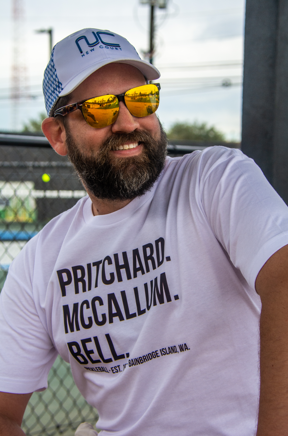 Man wearing pickeball founders tshirt that reads "Pritchard. McCallum. Bell. Pickleball - est. 1965 - Bainbridge island, WA."